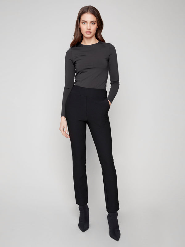 Dress pants in black with a flattering slim fit and practical side pockets, crafted from stretch fabric for ease of movement by Charlie B.