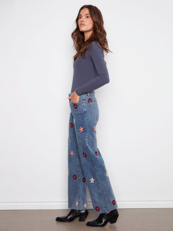 These five-pocket design jeans feature charming flower patches and a regular rise for added comfort by Charlie B.