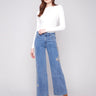 Blue jeans featuring a long length with intricate floral embroidery and sequins by Charlie B.