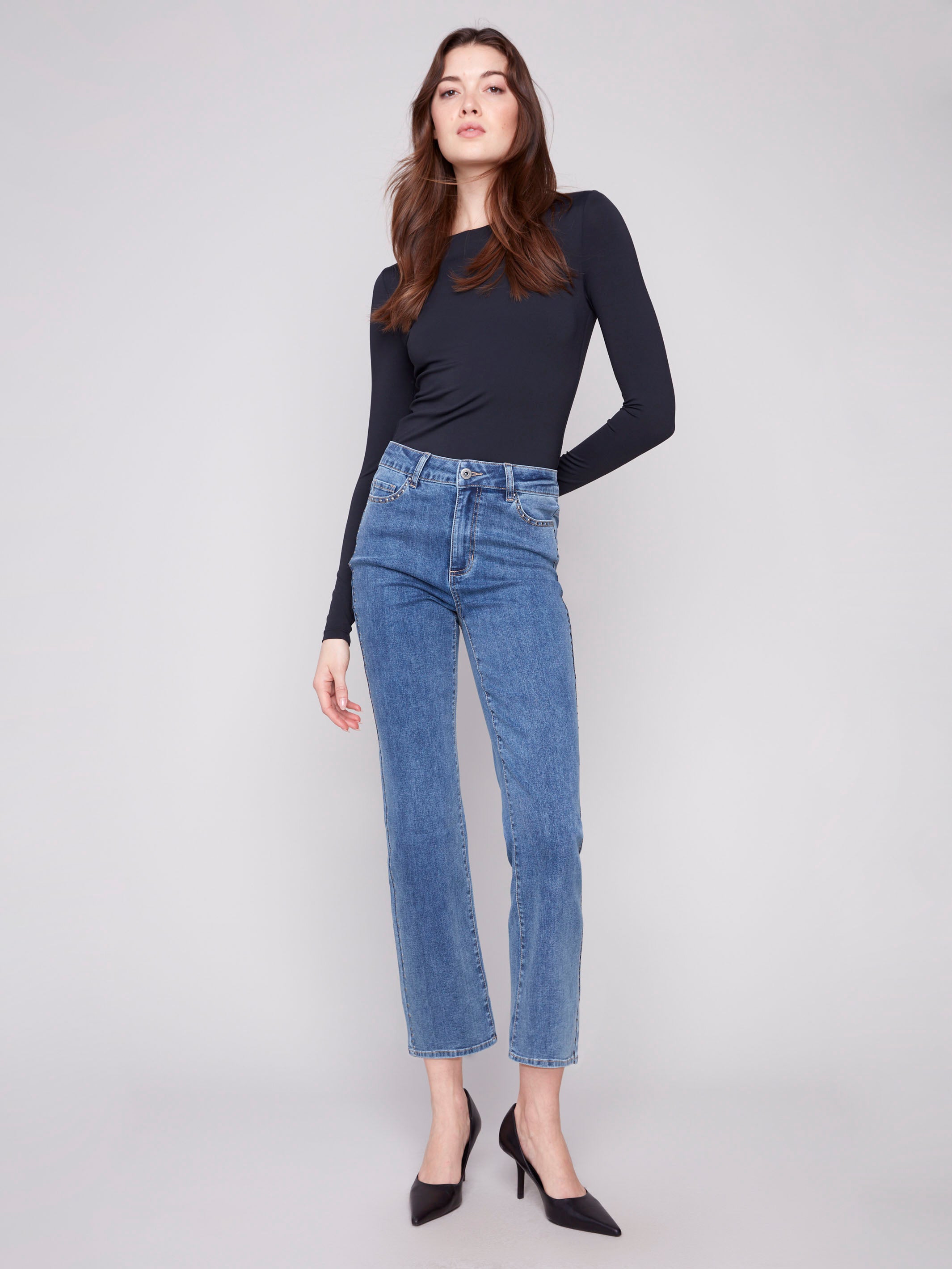 Medium blue denim jeans with a long length, featuring a button front closure and five-pocket design by Charlie B.