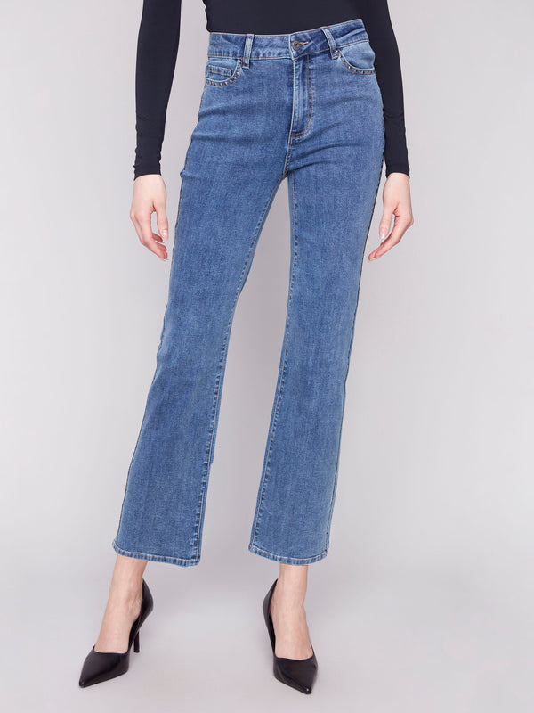 Blue denim straight-leg jeans with studs on pockets, offering stretch for comfort and style by Charlie B.