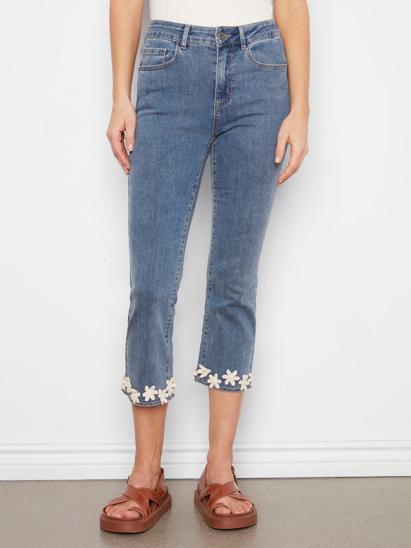 Cropped length jeans in medium blue, showcasing a floral hem trim with a comfortable stretch denim fabric by Charlie B.