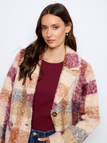 Model wearing a plaid boucle knit coat in stormy colors, highlighting the exquisite button closure by Charlie B.