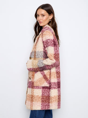 Model wearing a plaid boucle knit coat in taupe tones, emphasizing its refined longline design by Charlie B.