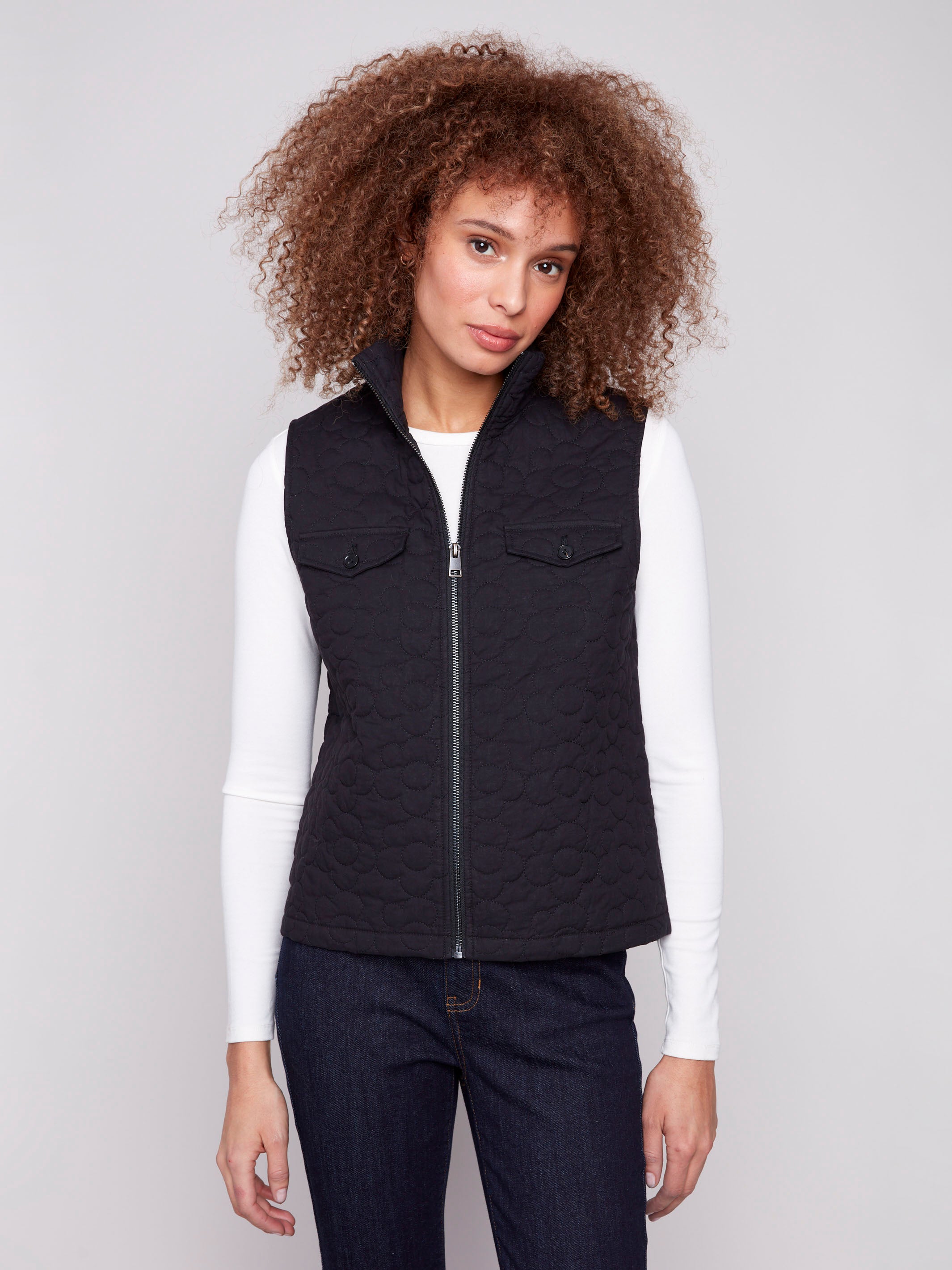 Black vest with quilted floral design, highlighted by convenient welt pockets and stylish high collar by Charlie B.