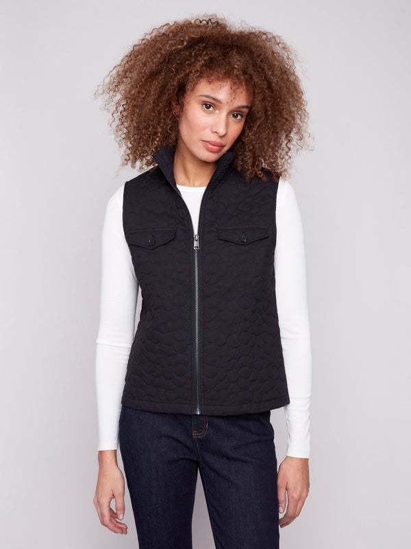 Black vest with quilted floral design, highlighted by convenient welt pockets and stylish high collar by Charlie B.