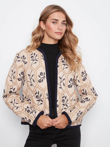 Intricate floral patterns on the quilted fabric make it a standout addition to any fashion-forward collection. By Charlie B.