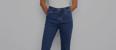 A woman wearing mid-wash bootcut jeans, a white fitted tee, and brown block heels. 