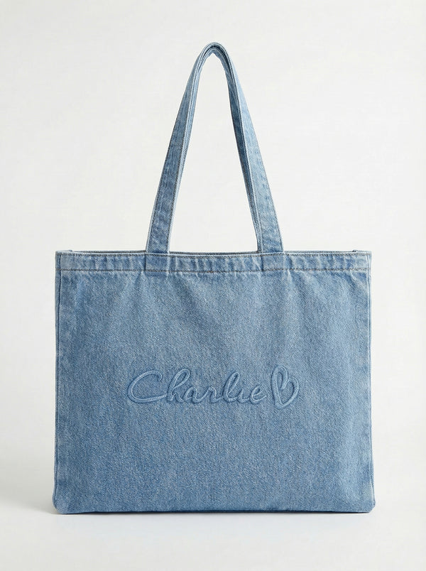 Denim tote bag crafted from 100% cotton, showcasing the embossed Charlie B logo. Features carry handles for easy portability by Charlie B.