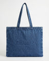 Denim tote bag with carry handles, featuring an embossed Charlie B logo. Spacious and stylish for everyday use by Charlie B.