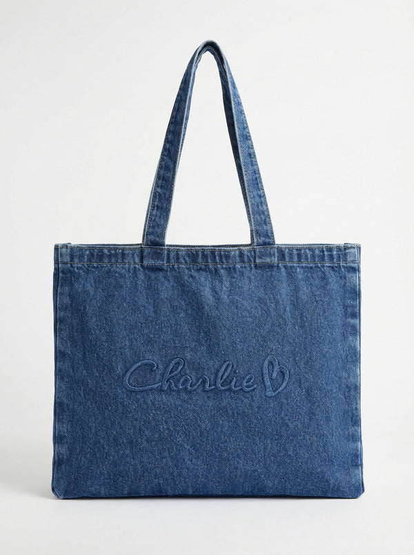 Denim tote bag with carry handles, featuring an embossed Charlie B logo. Spacious and stylish for everyday use by Charlie B.