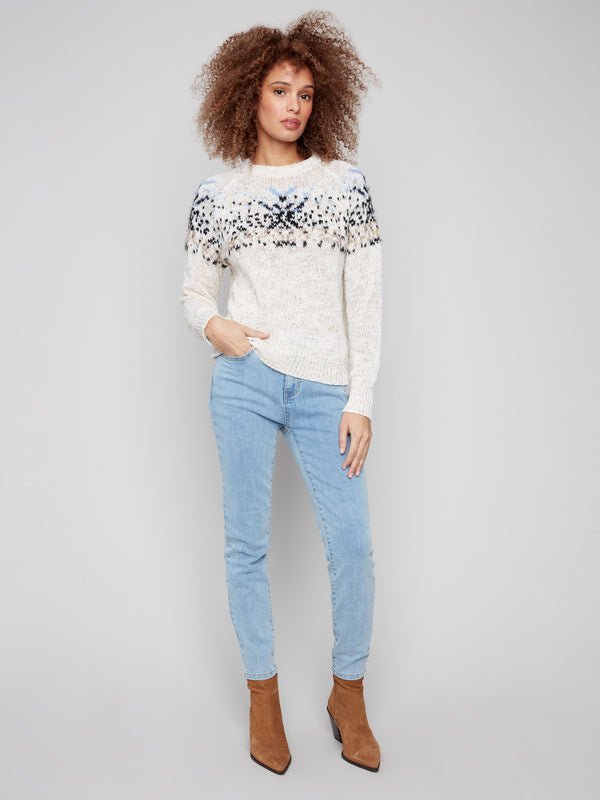 Stylish ecru sweater showcasing elegant raglan sleeves and geometric patterns by Charlie B.