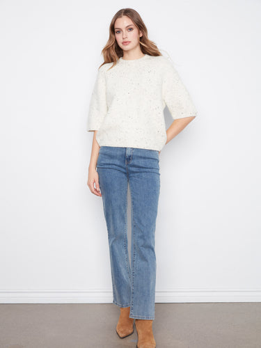 Chic speckled knit sweater in a relaxed fit, paired with classic blue jeans by Charlie B.