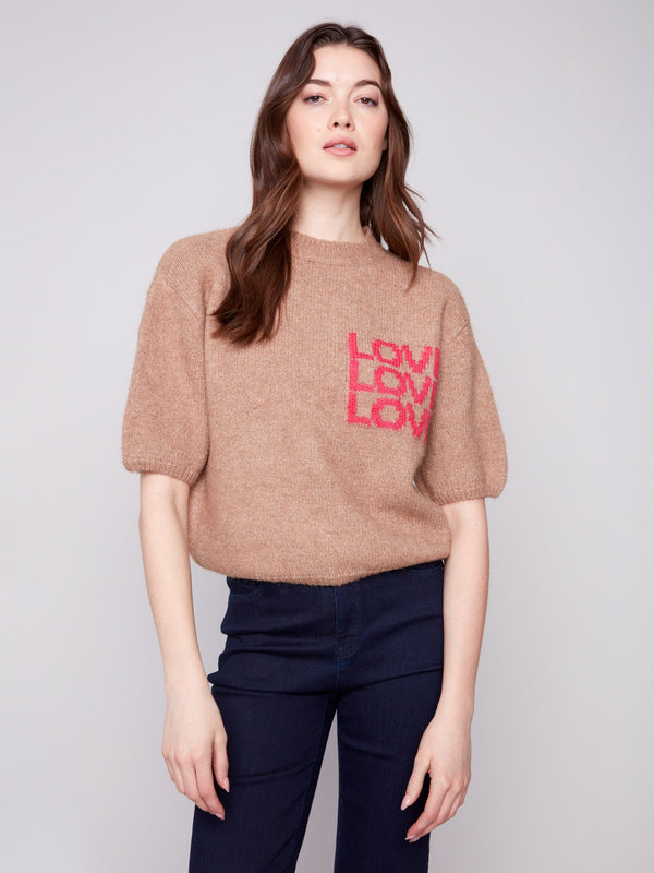 Stylish truffle sweater showcasing plush knit fabric and a charming 'LOVE' motif, designed for comfort by Charlie B.