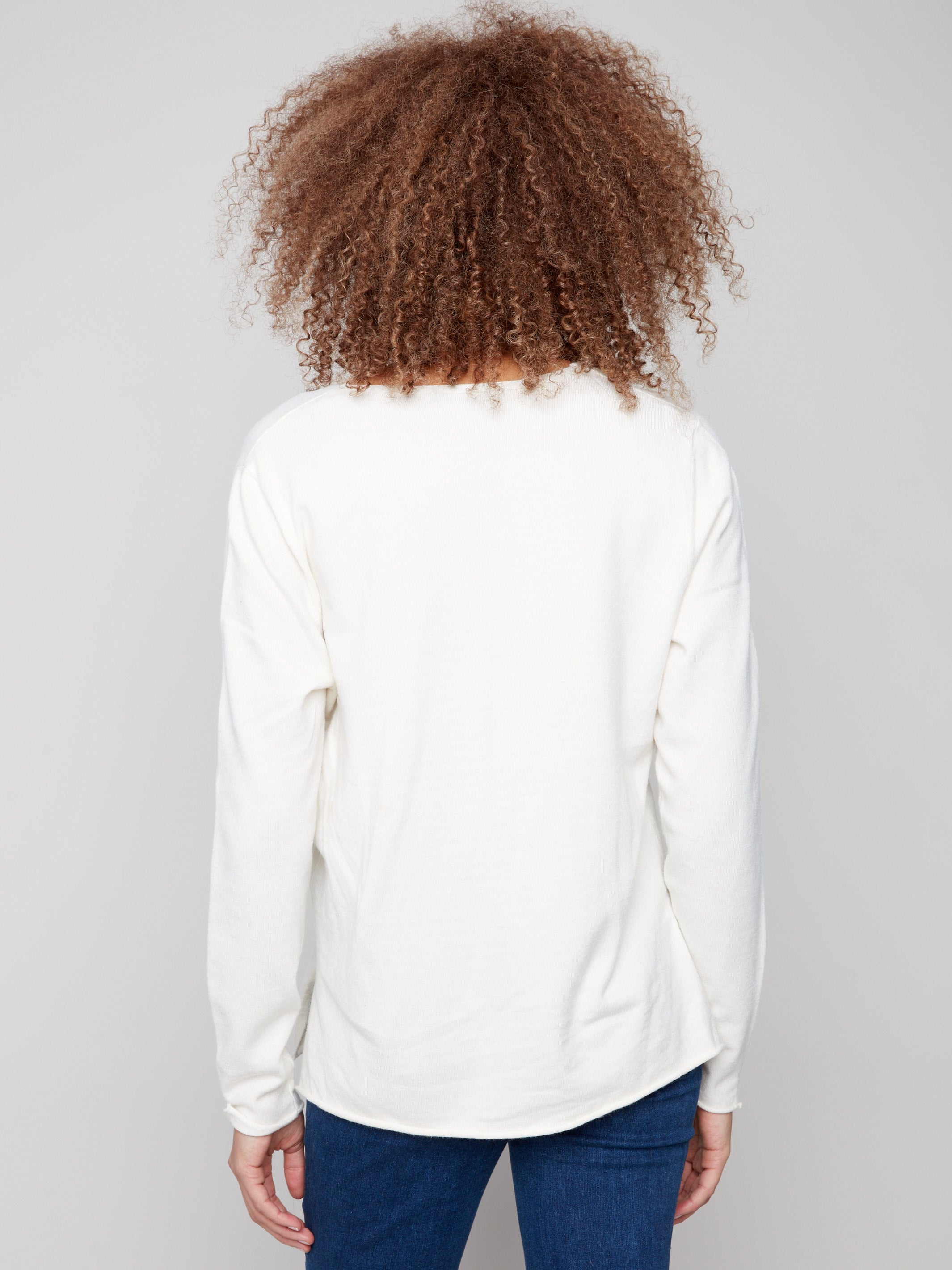 Classic ecru sweater featuring plush texture and side slits on hem, designed for both elegance and ease by Charlie B.