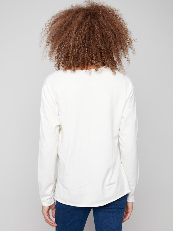 Classic ecru sweater featuring plush texture and side slits on hem, designed for both elegance and ease by Charlie B.