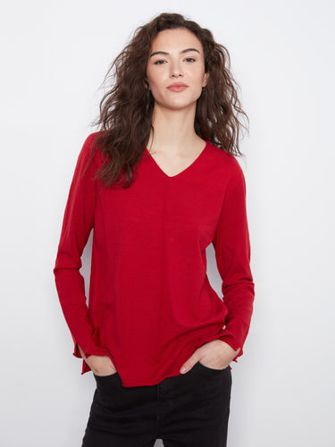 Red top with side slits adds a chic touch to your ensemble, enhancing movement and flair. Crafted by Charlie B.