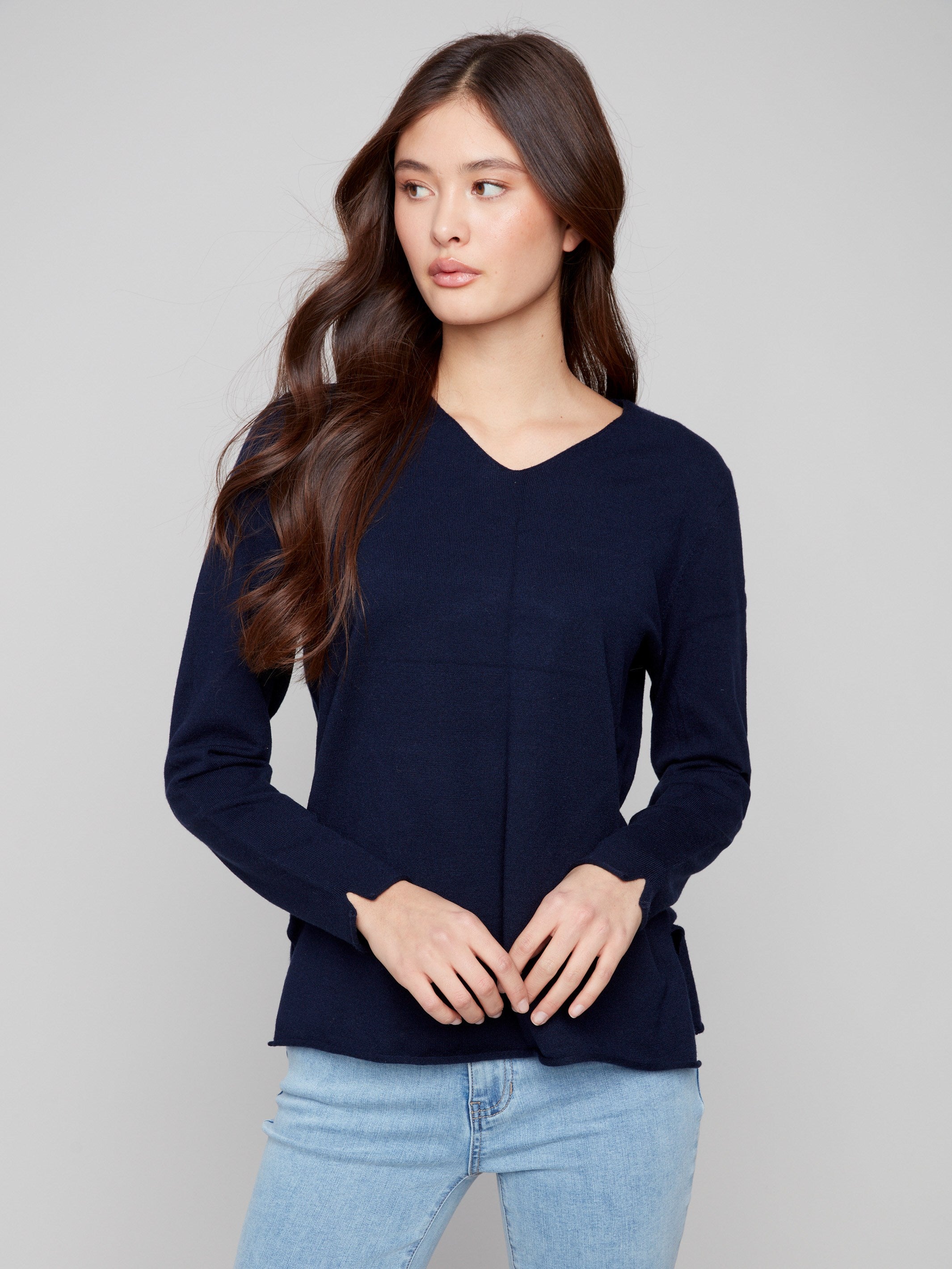 Navy V-neck sweater with side slits on sleeves and hem, providing a unique touch to its classic design by Charlie B.