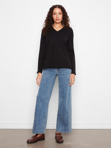 Black sweater crafted from soft knit fabric for warmth by Charlie B.