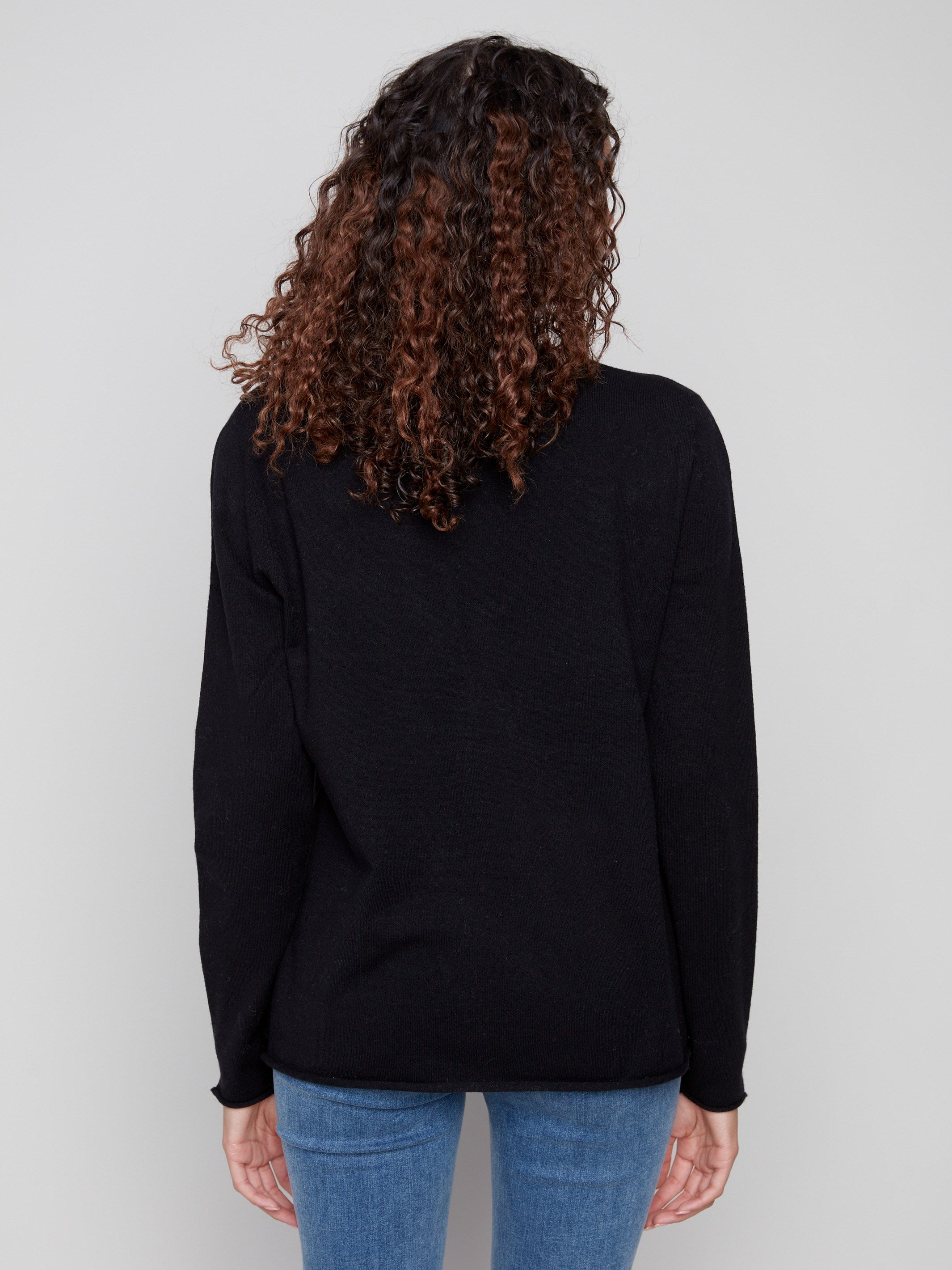 Classic black sweater with subtle side slits on sleeves, adding modern flair to a timeless piece by Charlie B.