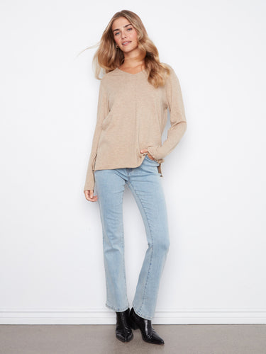 This beige top offers side slits, adding a stylish detail to your outfit. Comfortable and chic for everyday wear by Charlie B.
