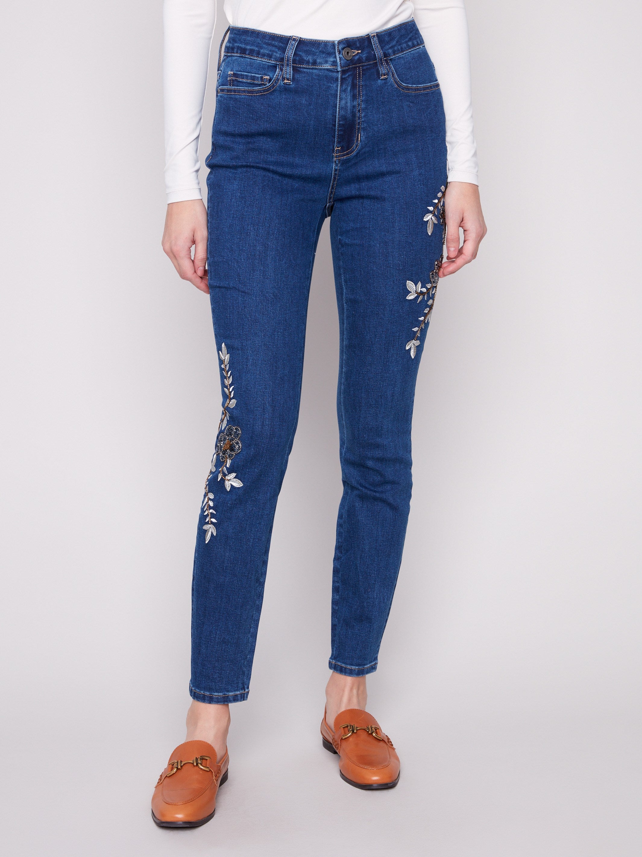 These jeans showcase a long length design with intricate floral embroidery, adding a touch of elegance by Charlie B.