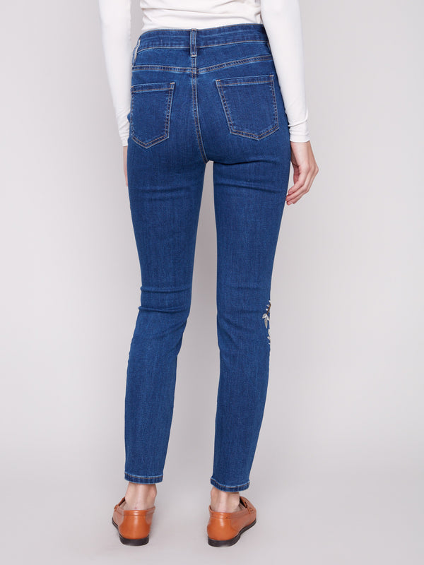 Skinny fit indigo jeans designed with a regular rise and adorned with delicate beaded patterns by Charlie B.