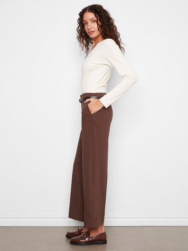 Brown crepe pants showcasing slash pockets, matched stylishly with a white top by Charlie B.