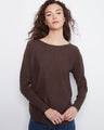 Brown sweater featuring a boat neck design, paired with blue jeans. The ribbed sleeves add texture to the outfit by Charlie B.