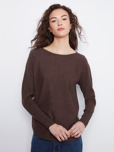Brown sweater featuring a boat neck design, paired with blue jeans. The ribbed sleeves add texture to the outfit by Charlie B.