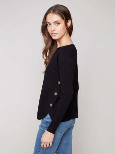 Black long-sleeve sweater showcasing ribbed sleeves for added texture by Charlie B.