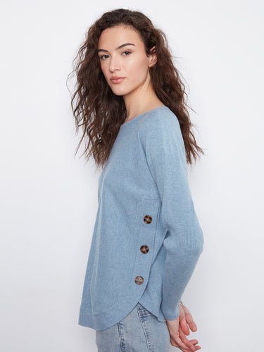 Chic light blue sweater featuring a rounded hem and elegant side button accents for a modern touch. By Charlie B.