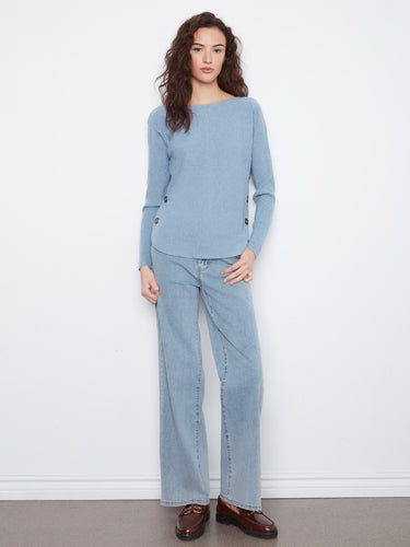 Stylish light blue sweater showcasing ribbed sleeves and eye-catching side buttons, perfect for any occasion. By Charlie B.
