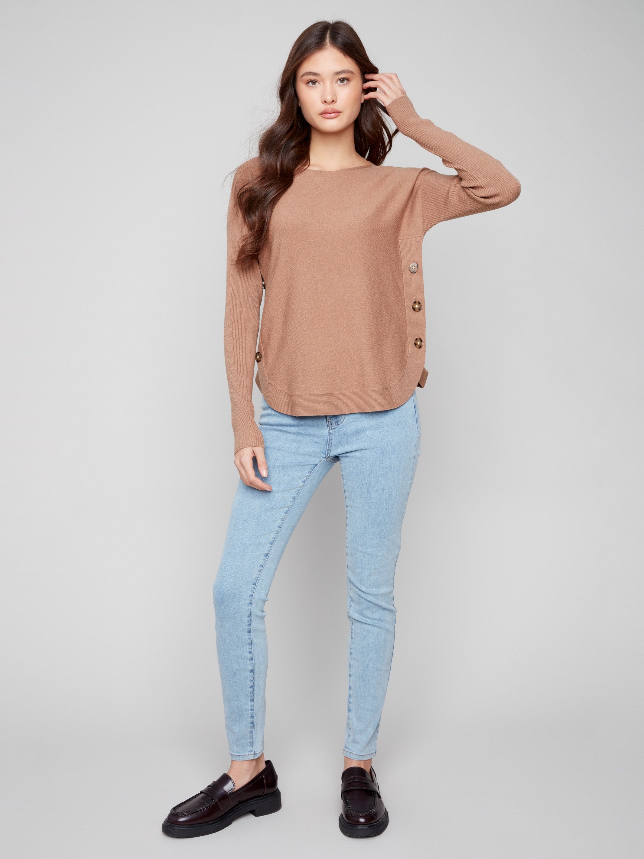 Elegant truffle sweater featuring rounded hem and chic side buttons, adding flair to your look by Charlie B.