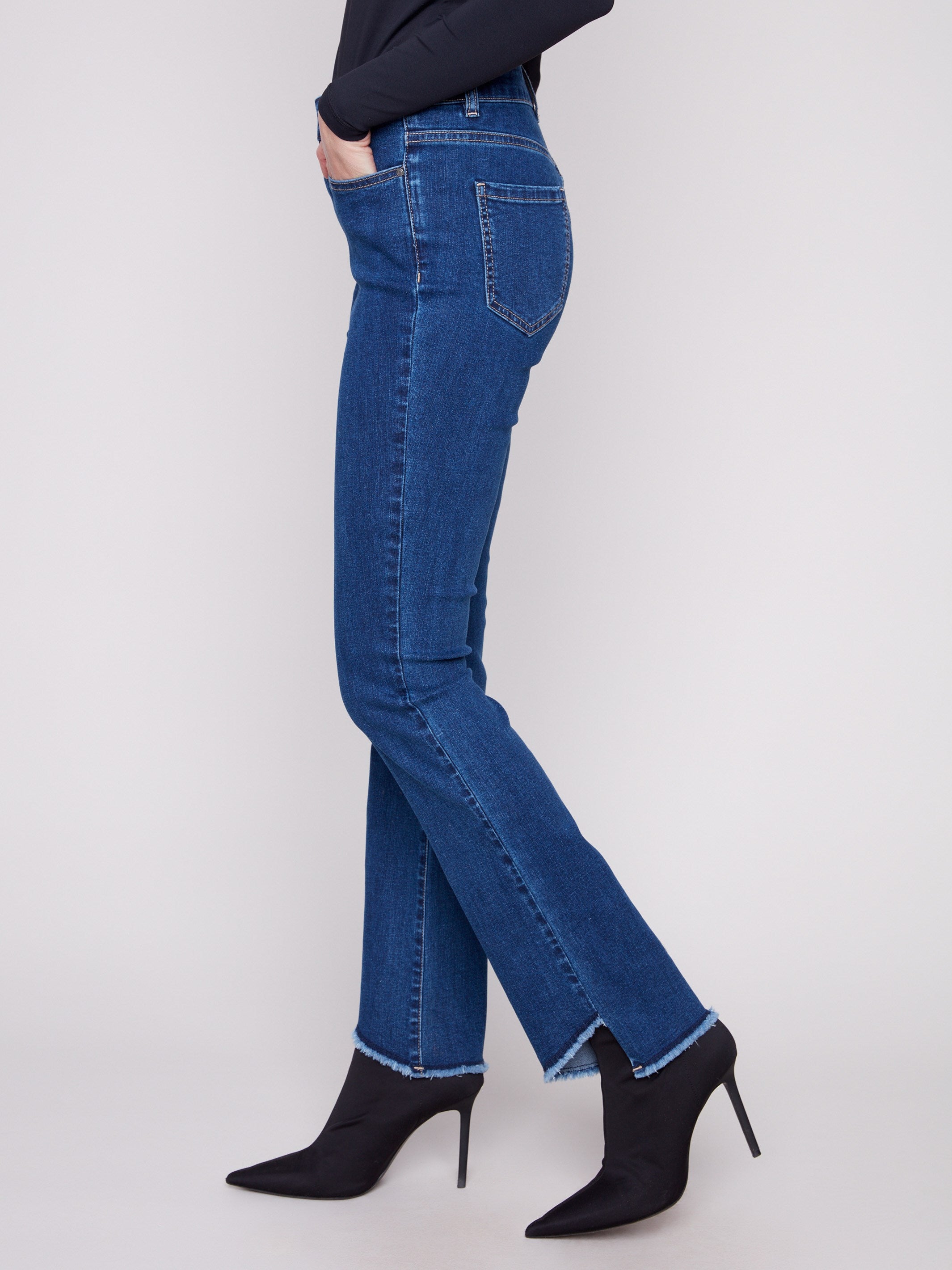 Denim jeans showcasing an asymmetrical fringed hem and bootcut fit for a trendy look by Charlie B.