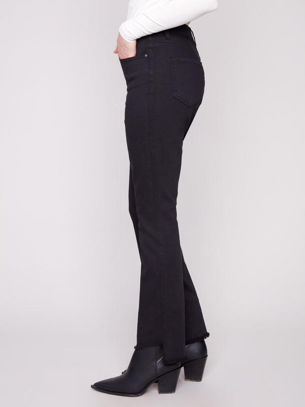 These stylish black pants showcase an asymmetrical fringed hem, adding a unique touch by Charlie B.