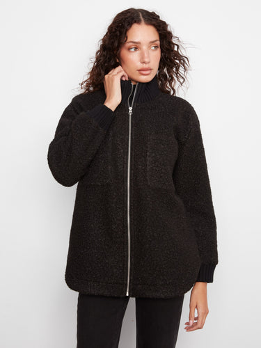 The coat's rounded hem offers a modern touch, enhancing its overall silhouette. By Charlie B.