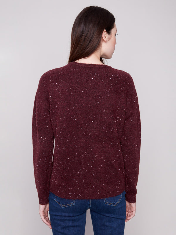 Elegant cabernet long-sleeve sweater with drop shoulder design and captivating speckled texture for added style by Charlie B.