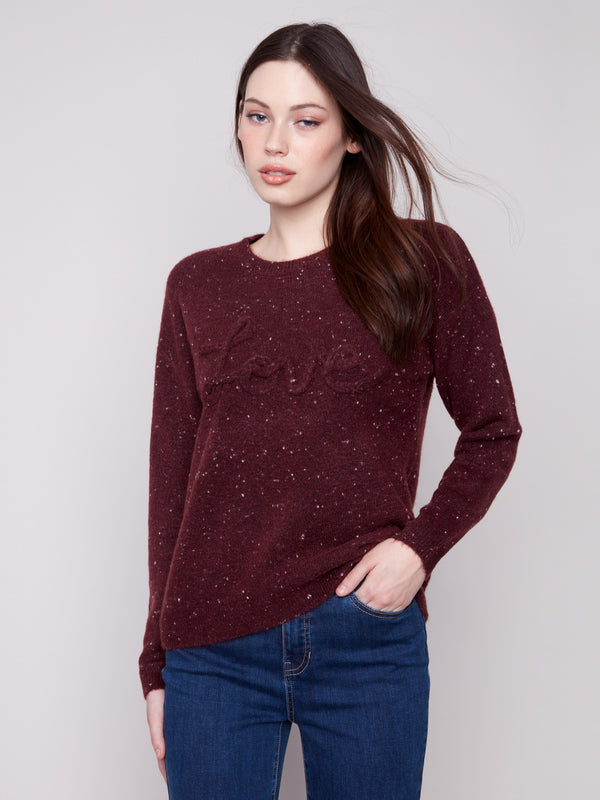 Fashionable cabernet crew neck sweater adorned with a striking braided 'Love' detail and stylish drop shoulders for flair by Charlie B.