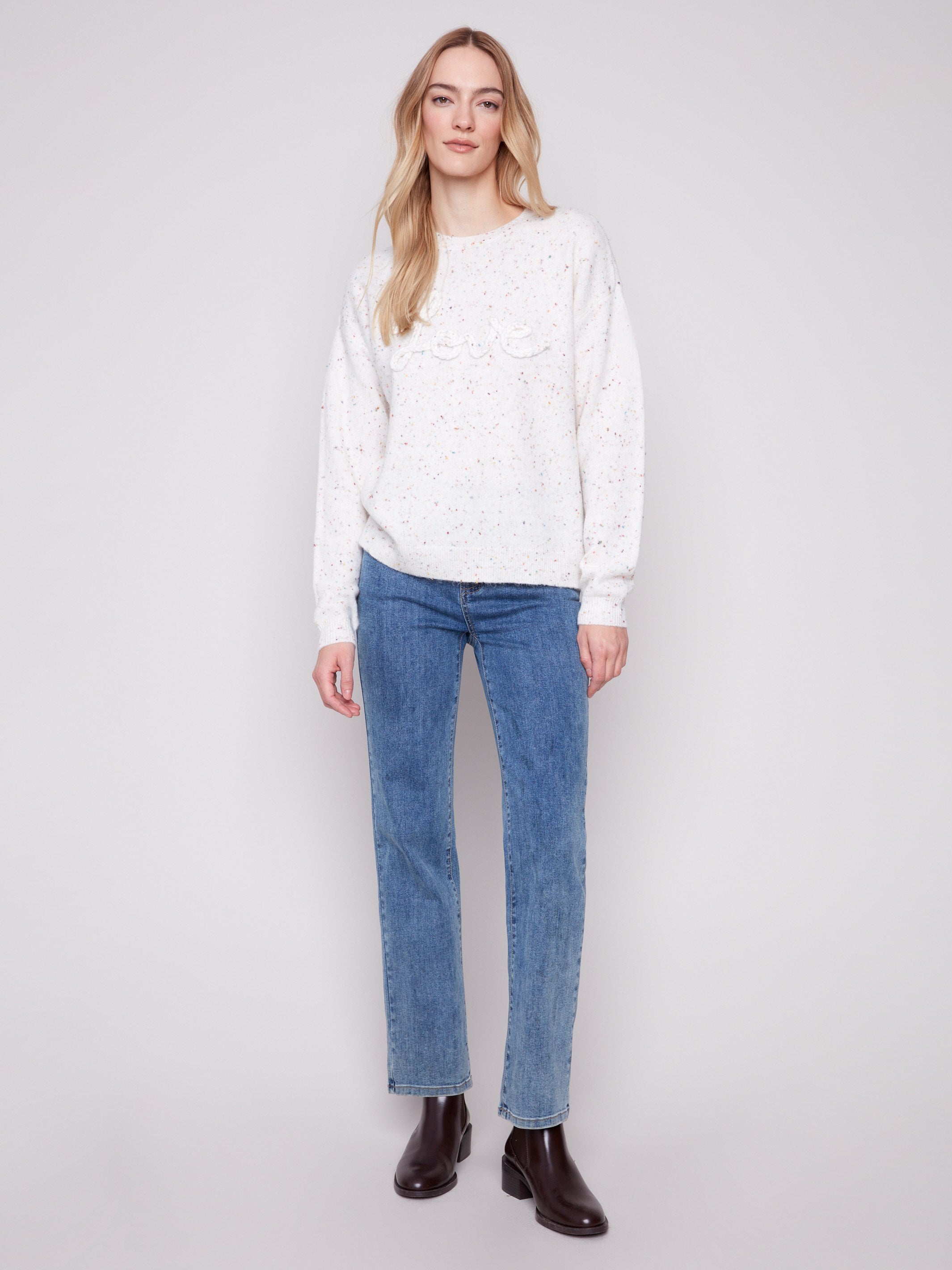 Stylish ecru sweater with long sleeves and a delightful braided 'Love' detail, perfect for cozy days by Charlie B.