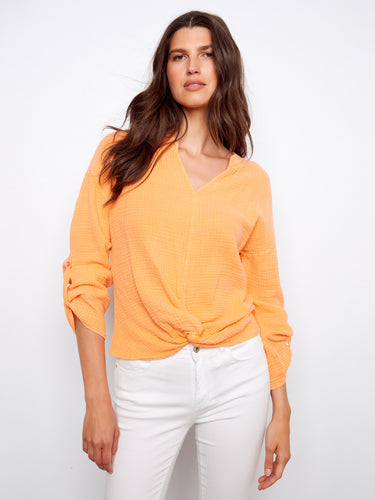 The notch neckline adds a touch of sophistication to this vibrant orange top, perfect for any occasion. Made from 100% cotton by Charlie B.