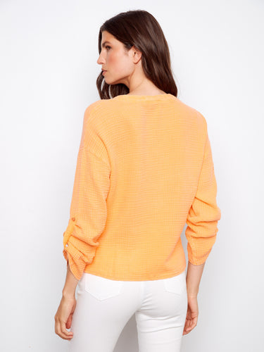 This orange top combines chic design with comfort, thanks to its lightweight 100% cotton fabric and modern front knot detail by Charlie B.