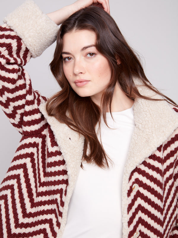 Elegant jacket showcasing bouclé chevron pattern and button closure, perfect for any occasion by Charlie B.