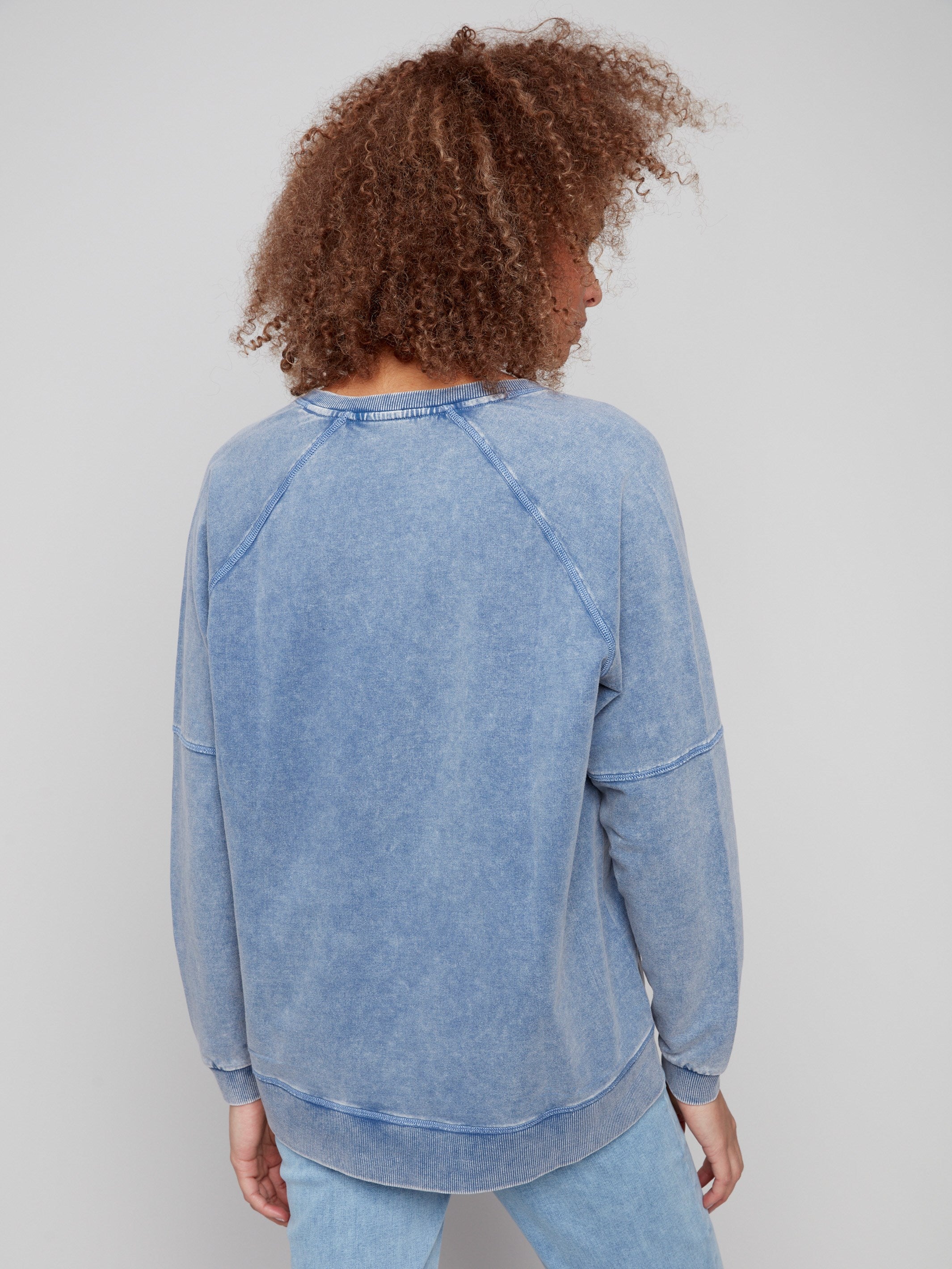Slit hem detail enhances the casual vibe of this versatile denim V-neck top by Charlie B.