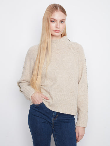 Beige sweater featuring a mock neck and folded cuffs, perfect for cozy days. Styled with long raglan sleeves by Charlie B.