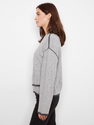 Elegant gray sweater showcasing wide sleeves and contrast trim for added flair by Charlie B.