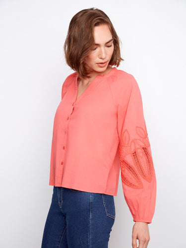 Stylish coral top showcasing beautiful sleeve embroidery and elastic cuffs for added comfort. By Charlie B.