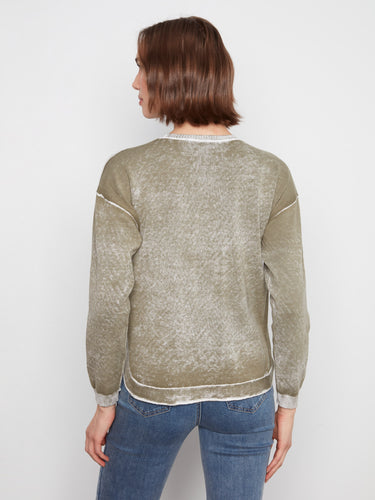 A rounded hem adds a subtle touch of elegance to the overall design of the sweater. By Charlie B.