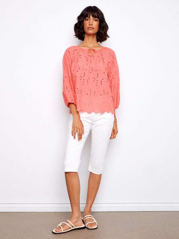 This coral top showcases intricate eyelet detailing, perfect for a breezy and stylish look by Charlie B.