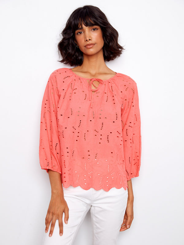 Designed with 3/4 sleeves, this coral blouse offers both comfort and style for any occasion by Charlie B.